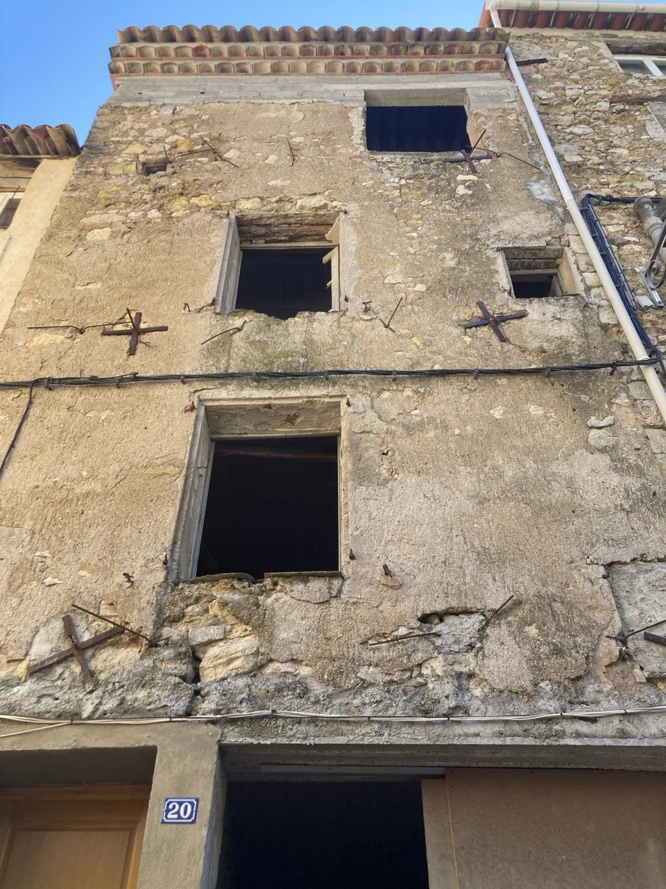 Weathered stone house facade with open windows